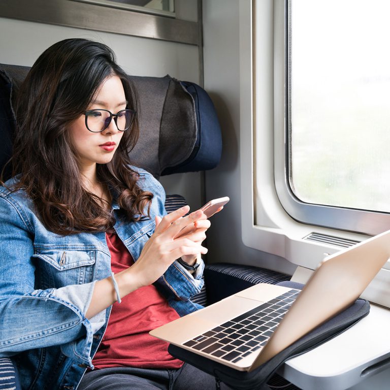 Person on train using multiple devices - Asset security - ExactTrak